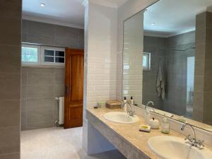 ein Badezimmer mit zwei Waschbecken und einem großen Spiegel in der Unterkunft Preciosa casa entre Lisboa, Cascais y Sintra in Fuente el Saz