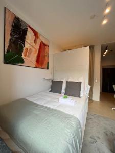 a bedroom with a large bed with a large painting on the wall at Quiet and sunny studio in Ddorf absolut city center in Düsseldorf