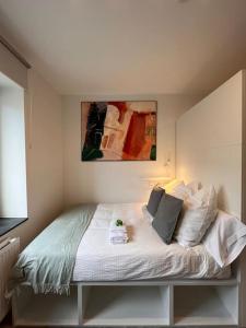 a bed in a bedroom with a painting on the wall at Quiet and sunny studio in Ddorf absolut city center in Düsseldorf