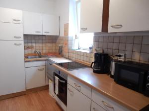 een keuken met witte kasten en een aanrecht bij Ferienwohnung Marbach-Zentrum in Marbach am Neckar