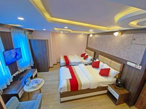 1 dormitorio con 2 camas, escritorio y TV en Hotel White Rabbit en Katmandú