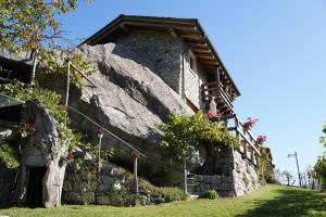 un edificio in pietra con dei fiori sul lato di RUSTICO VIGNA casa vacanze a Civo Altre 36 foto