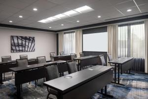 a conference room with tables and chairs and a screen at Fairfield Inn & Suites by Marriott Cleveland Tiedeman Road in Brooklyn