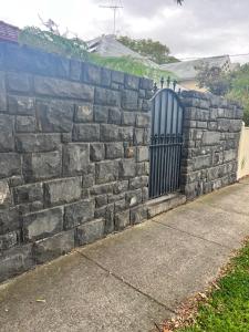 una pared de piedra con una puerta negra en Seaside cottage, en Sandringham