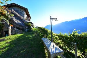 una panchina posta su una collina accanto a un edificio di RUSTICO VIGNA casa vacanze a Civo