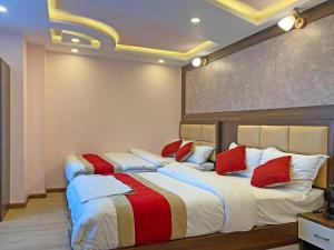 a bedroom with two beds with red and white pillows at Hotel White Rabbit in Kathmandu