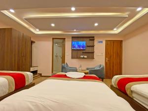 a hotel room with two beds and a tv at Hotel White Rabbit in Kathmandu