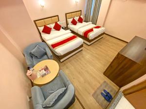 a small room with two beds and a table and chairs at Hotel White Rabbit in Kathmandu