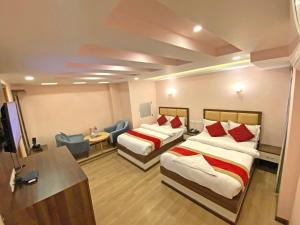 a hotel room with two beds and a desk at Hotel White Rabbit in Kathmandu