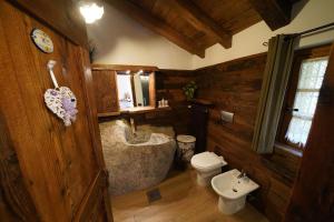 ein Badezimmer mit einer Badewanne, einem WC und einem Waschbecken in der Unterkunft RUSTICO VIGNA casa vacanze in Civo