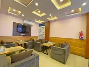 a restaurant with tables and chairs and a flat screen tv at Hotel White Rabbit in Kathmandu