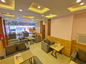 a restaurant with tables and chairs and a tv at Hotel White Rabbit in Kathmandu