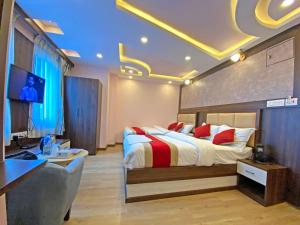 a bedroom with a bed and a desk and a television at Hotel White Rabbit in Kathmandu