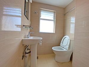 a bathroom with a sink and a toilet and a window at Hotel White Rabbit in Kathmandu