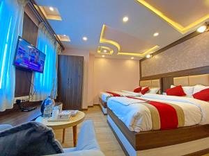 a hotel room with two beds and a flat screen tv at Hotel White Rabbit in Kathmandu