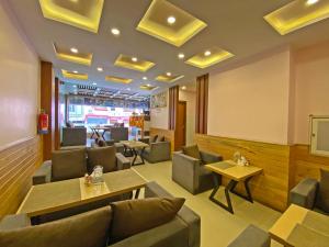 a restaurant with couches and tables and chairs at Hotel White Rabbit in Kathmandu