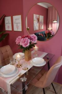 una sala da pranzo con pareti rosa e specchio di Designer Luxury Apartment near Prater a Vienna