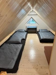 um quarto no sótão com 2 camas e uma janela em Chalupa Jarka em Jablŭnka
