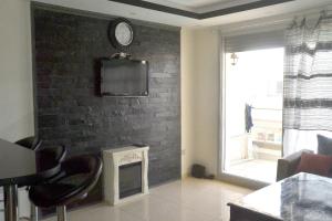 salon z telewizorem na murze w obiekcie Apartment am Meer mit Pool w mieście Aurir