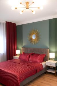 a bedroom with a red bed with red sheets and a mirror at Designer Luxury Apartment near Prater in Vienna