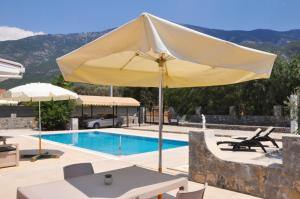 una sombrilla amarilla grande junto a la piscina en Villa Steve en Fethiye