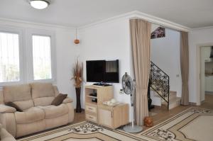 a living room with a couch and a television at Villa Steve in Fethiye