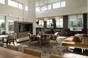 a large room with tables and chairs and a flat screen tv at Residence Inn by Marriott Green Bay Downtown in Green Bay