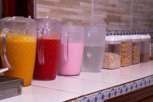 een rij plastic containers gevuld met verschillende gekleurde vloeistoffen bij Pousada Villa Blu Maresias in Maresias