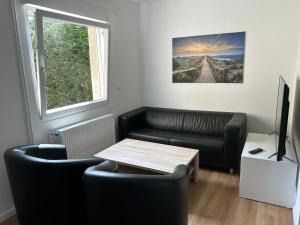 sala de estar con sofá y mesa en Moderne Service Apartment / Ferienwohnung, en Recklinghausen
