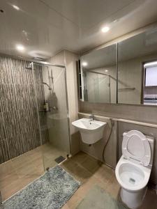 a bathroom with a shower and a toilet and a sink at Spacious Luxury Condo w/ kitchen beside Hilton Clark D’Heights in Pampang