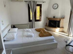 a white bedroom with a bed and a fireplace at Oasi in Kato Loutraki