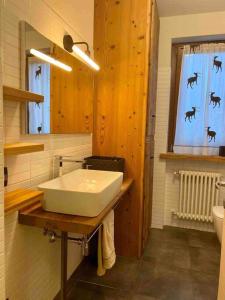 ein Badezimmer mit einem weißen Waschbecken und einem Spiegel in der Unterkunft La petite maison d'Erika in Aosta