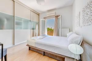 Un dormitorio blanco con una cama grande y una ventana en Villa Maria Fabrika Syros, en Vári