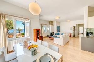 a kitchen and living room with a table and chairs at Villa Maria Fabrika Syros in Vári