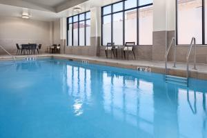 a swimming pool with blue water in a building at Courtyard by Marriott Owatonna Downtown in Owatonna