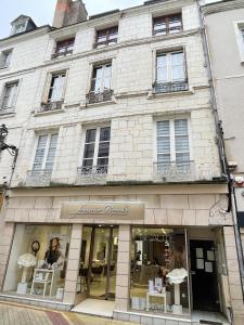 una tienda frente a un edificio de ladrillo blanco en Magnifique logement au pied du Château en Blois