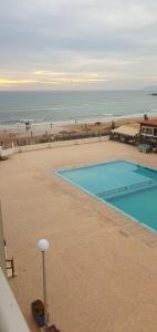 a swimming pool on the beach next to a beach at Apartment am Meer mit Pool in Aourir