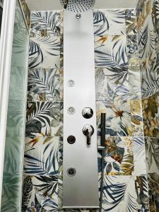 La salle de bains est pourvue d'une cabine de douche et de papier peint à fleurs. dans l'établissement Loft La Lanterna, à Gênes