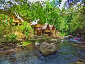 a house by a stream in front of a house at Aksha Riverside Ubud in Tampaksiring