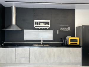 a kitchen with a sink and a black wall at Stay Timoga - Private Poolvilla in Muju