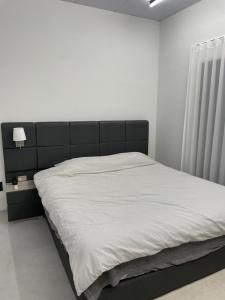 1 cama con cabecero negro en un dormitorio en 신규오픈, 프라이빗 독채 풀빌라 펜션, 스테이티모가, en Muju