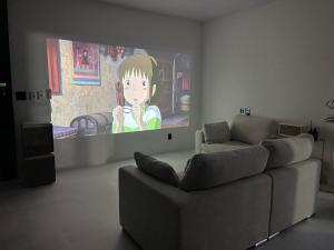 sala de estar con TV y sofá en 신규오픈, 프라이빗 독채 풀빌라 펜션, 스테이티모가, en Muju