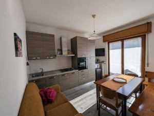 a kitchen with a couch and a table in a room at Appartamenti Pedrini in Comano Terme
