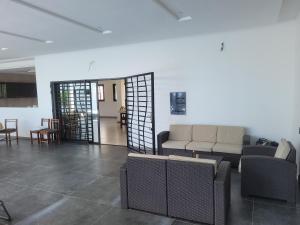 Villa Sylla fall في توباب ديالاو: غرفة معيشة مع أريكة وطاولة وكراسي