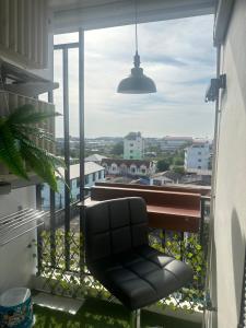 einen schwarzen Stuhl auf einem Balkon mit Aussicht in der Unterkunft คอนโด รังสิตใกล้ฟิวเจอร์พาร์ค 1 ห้องนอน in Ban Talat Rangsit