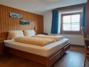 a bedroom with a large bed with a window at Pension zu Hause in Uttendorf