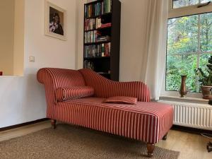 sala de estar con sofá y estante para libros en De Compaenenhorst, en IJhorst