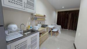 een kleine keuken met een wastafel en een tafel bij Cozy Apartment Chaweng Center in Chaweng Beach