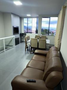 ein Wohnzimmer mit einem Sofa und einem Esszimmer in der Unterkunft Residencial Wrubleski SC in Pinheira