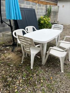 una mesa y sillas blancas y una sombrilla en DUPLEX REFAIT NEUF à MONCHAUX SORENG, en Monchaux-Soreng